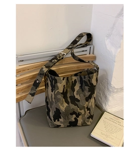 Close-up of canvas bucket bag with camouflage pattern and metal eyelet shoulder strap