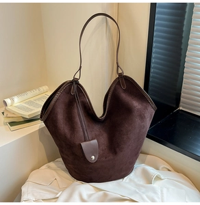 Close-up of deep brown suede tote bag featuring silver buckle and V-shaped opening