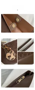 Detail view of brown tote bag features leopard print charm and precise stitching details