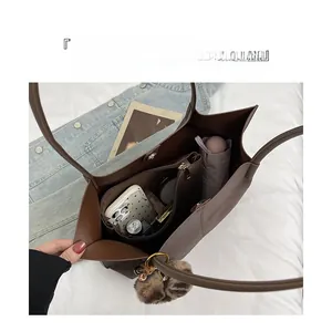 Detail showing the spacious interior compartments and golden magnetic clasp of the tote bag