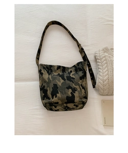 Flat lay of camo canvas shoulder bag with wide strap on white fabric background