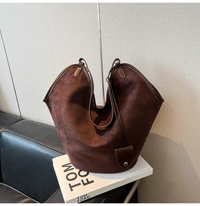 Detailed close-up of dark brown suede tote bag showing soft texture and metal buckle
