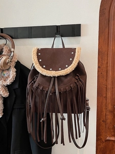 Vintage brown leather backpack with star rivets, long tassels and plush sheepskin trim