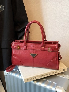 Retro red leather tote bag with gold triangle plaque and buckle on metallic suitcase