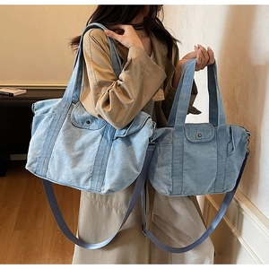 Detail shot of two denim tote bags in light blue wash showing size comparison and texture