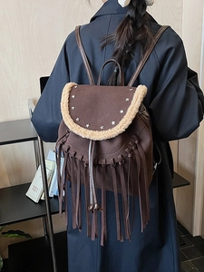 Brown vintage bohemian backpack with fringe, silver star accents and plush trim details