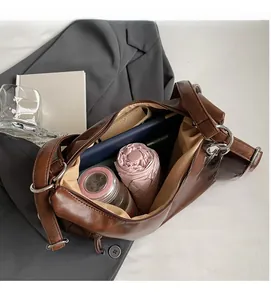 Macro shot showing the spacious interior of the deep brown leather tote bag with essentials