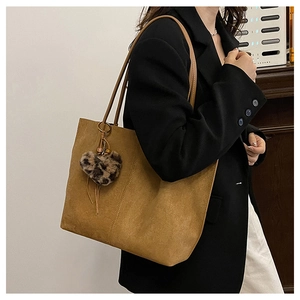 Brown suede tote bag detail featuring leopard print heart charm and long shoulder strap
