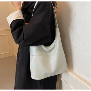 Detail der hellgrünen Tragetasche mit Lychee-Struktur und großen Vordertaschen für den Alltag
