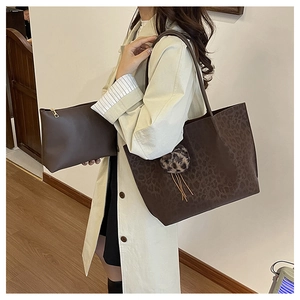 Detail of leopard print tote and pouch set styled with an elegant beige trench coat