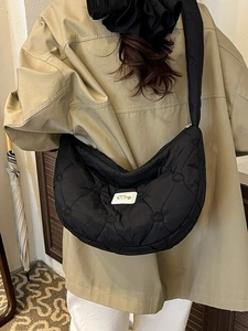 Black quilted cloud hobo bag featuring heart patterns and adjustable wide strap