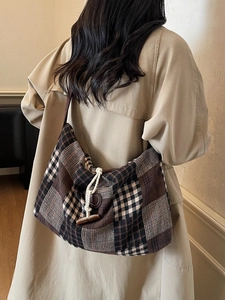 Grand sac cabas rétro à carreaux avec fermeture à bascule porté par un mannequin en trench