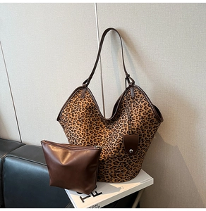 Detail of leopard print tote bag with brown leather trim and matching inner pouch