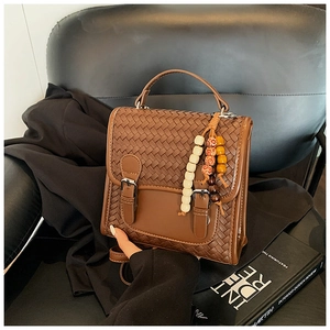 Detailed view of brown woven leather texture with metallic buckles and colorful beads