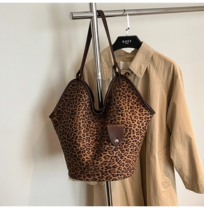 Close-up of leopard print suede tote bag with brown leather handles and large capacity