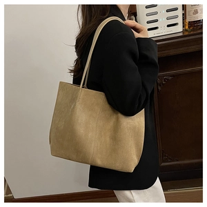 Detail view of large brown suede tote bag with slim shoulder straps for casual commuting