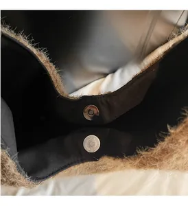 Detailed macro view of the silver magnetic closure and plush texture on the faux fur handbag