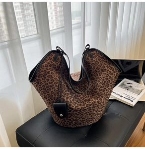 Detail of leopard print faux suede tote bag with black leather straps and mini pouch accessory