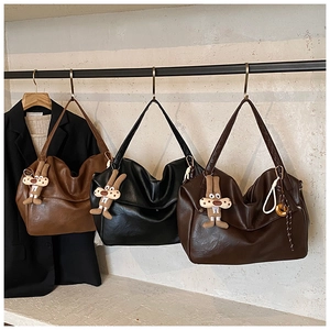 Detailed macro view of large vintage tote bags in brown and black with plush charms