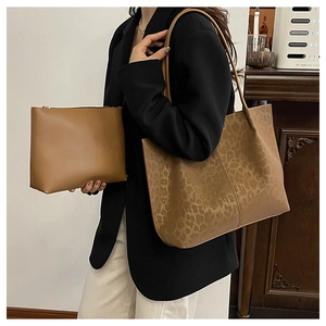 Detailed close-up of leopard print tote bag paired with matching brown zipper pouch set