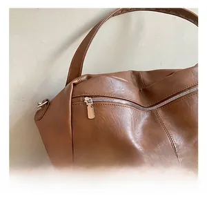Close-up of silver zipper hardware and brown leather texture on a fashion handbag