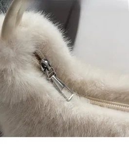 Nahaufnahme eines glatten silbernen Metallreißverschlusses an weißer Kunstfelltasche