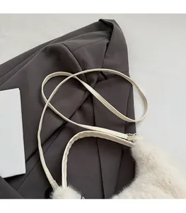 Detailaufnahme der cremefarbenen Plüsch-Umhängetasche mit schmalem Leder-Schultergurt