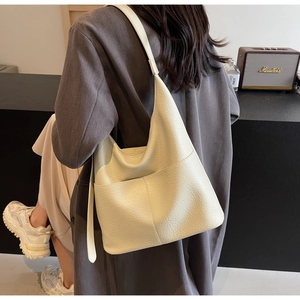 Detailaufnahme der beigen Tragetasche aus genarbtem Leder mit praktischer Vordertasche
