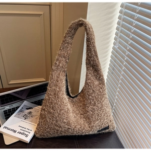 Detail of a brown fuzzy plush tote bag showing high-density faux fur texture and black tag
