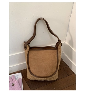 Dettaglio della borsa a secchiello invernale in pelle scamosciata marrone e shearling beige
