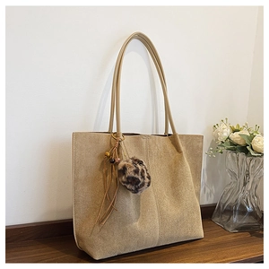 Close-up of khaki suede tote bag with leopard print pompom and beaded tassel detail