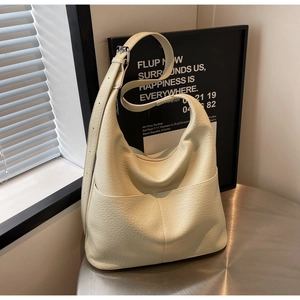 Detail der cremefarbenen Hobo-Tasche mit Lychee-Lederstruktur und verstellbarem Gurt