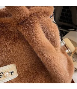 Detailopname van bruine pluche tas met parelbandlabel en zachte imitatiebonttextuur