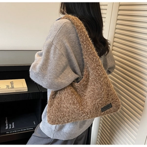 Brown fluffy faux fur tote bag with leather label shown in a cozy autumn setting