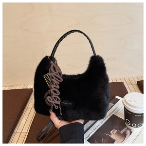 Detail der flauschigen schwarzen Kunstpelz-Hobo-Tasche mit Anhängern und Love-Tag