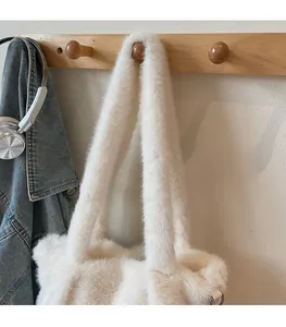 Detail showing plush faux fur texture and wide shoulder strap of the white tote bag