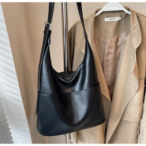 Detailansicht der schwarzen Hobo-Tasche aus Narbenleder mit Seitentaschen und Trageriemen