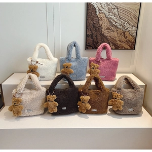 Detail of colorful plush bucket bags with teddy fur texture and cute bear charms