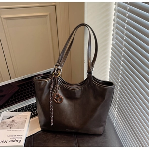 Detail einer dunkelbraunen Leder-Shopper-Tasche mit Knotenkordel im Büro-Ambiente