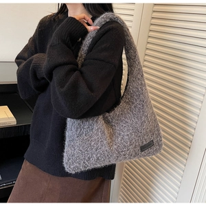 Detail of soft grey faux fur hobo bag with chain strap and chic leather brand logo
