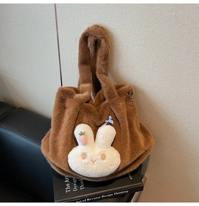 Detailed shot of brown plush bucket bag with a cute 3D bunny mascot and bow decoration