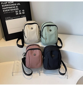 Mini canvas crossbody phone bags displayed in beige, green, pink and black colors