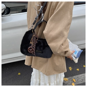 Detailansicht der schwarzen Plüsch-Handtasche mit Love Every Day Lederpatch und Anhängern