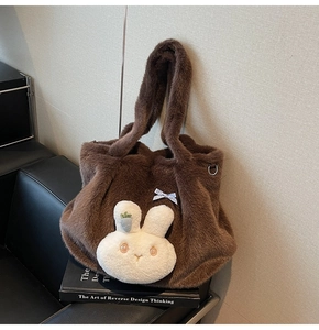 Detail of dark brown plush tote bag featuring a cute white bunny head and carrot accent