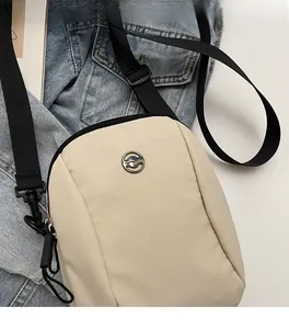 Detail of beige waterproof oxford cloth mini crossbody bag with metal kangaroo logo