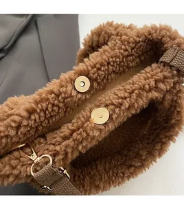 Close-up of brown plush crossbody bucket bag with golden magnetic snap closure and texture