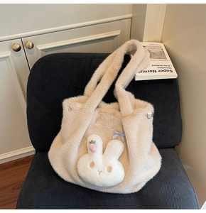 Close-up of beige plush tote bag with cartoon rabbit character and carrot embroidery detail