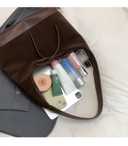 Detail view of large brown suede tote bag showing spacious interior with daily essentials