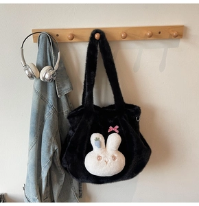 Detail of plush black tote bag featuring a cute white bunny and red checkered bow