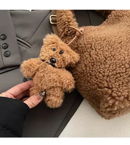 Detailed view of dark brown faux fur teddy bear charm on matching bucket bag strap